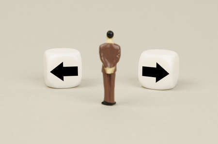 business concept. A human figurine stands in front of white cubes with inscriptions - left or right