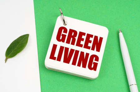 ecological concept. On a white-green surface, a piece of paper, a pen and a notepad with the text - Green Livingの写真素材
