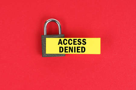 business and security concept. On the red surface there is a lock with a sticker with the inscription - access deniedの写真素材