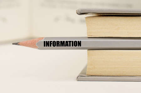 education concept. In the book between the pages lies a pencil with the inscription - Informationの写真素材