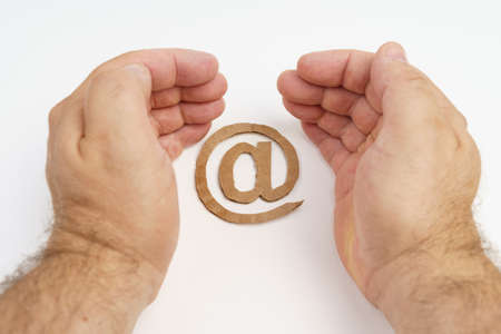 On a white background, the symbol of the email, inside the hands of a man. communication conceptの写真素材