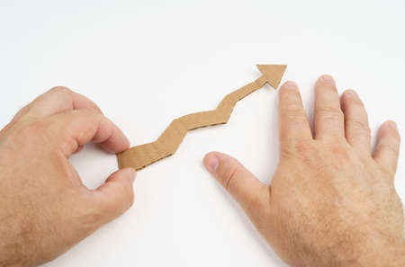 A man holds a growth arrow in his hands on a white background. growth symbolの写真素材