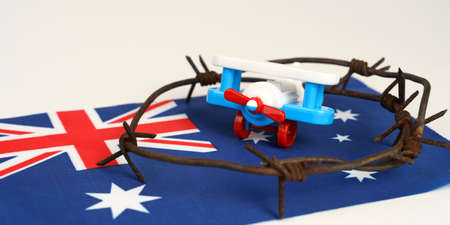 Toy plane, Australian flag and barbed wire on a white background. fly ban conceptの写真素材