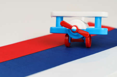 A toy plane stands on the flag of Russia. travel and business concept