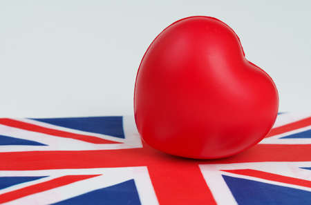 On a white background is the flag of Great Britain, on it lies a red heart. Patriotismの写真素材