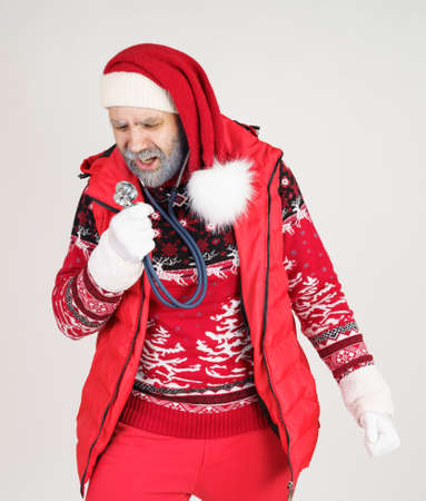 Christmas holidays concept. Santa Claus sings songs into a stethoscope. white background.