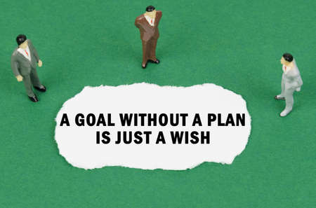 business and finance concept. On the green surface there are figures of businessmen and there is torn paper with the inscription - A Goal Without a Plan Is Just a Wishの写真素材