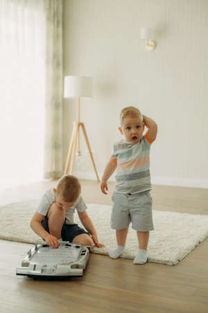 Children sit on the floor and play table hockey. children's games.の写真素材