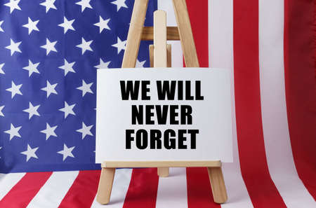 The flag of the United States has a sign that says - We will never forget. USA. Memorable days