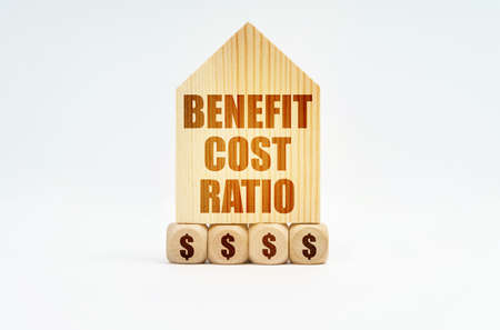 real estate and business. On a white surface stands a wooden model of a house with the inscription - Benefit cost ratioの写真素材