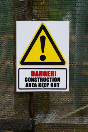 security concept. On the fence hangs a warning sign and a sign with the inscription - danger construction area keep outの写真素材
