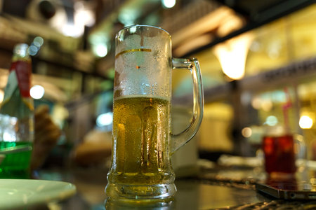 A misted glass in the beams of the interior lighting of the bar. close-up.の写真素材