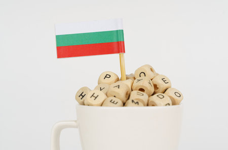 The flag of Bulgaria sticks out of a cup with cubes on which letters are depicted. Symbol of education. close upの写真素材