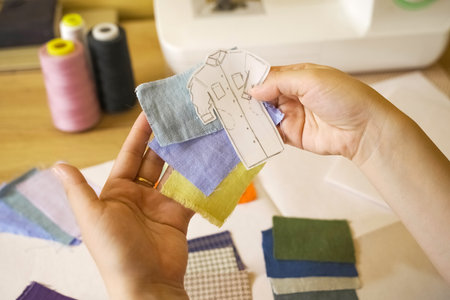A clothing designer makes sketches, selects fabrics, colors. close-up. small business