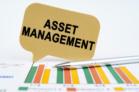 business concept. On the financial charts lies a pen and a sign with the inscription - asset managementの写真素材