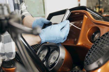 The mechanic installs a tablet on a motorcycle. close-up.の写真素材