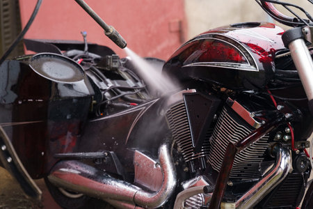 Washing a motorcycle engine with a high pressure jet. close-up.の写真素材