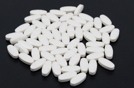 medical background. White pills lie on a black background.の写真素材