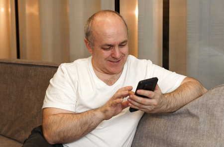 A man sits on the couch and browses social networks and videos. close-up.