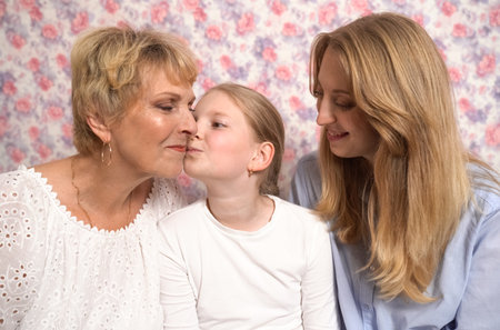 A teenage girl hugs and kisses her grandmother and mother, expresses her love to them.の写真素材