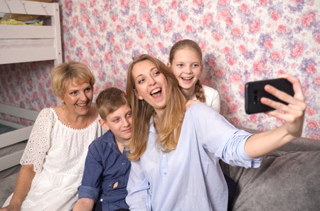 Happy woman takes selfie with kids and grandma.の写真素材