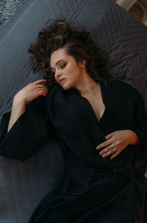 Happy beautiful young woman waking up after a healthy sleep, lying in a cozy comfortable bed. view from above.の写真素材