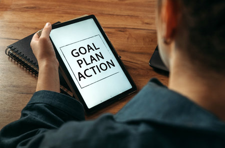 business concept. A woman holds a tablet in her hands on the screen of which it is written - goal, plan, actionの写真素材