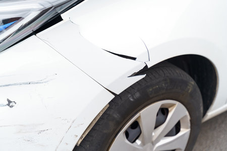car accident or crash. Damaged front left fender of a passenger car close-up.の写真素材