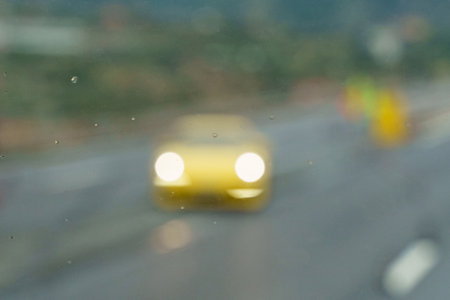 background image. Blurred image of a yellow sports car with headlights on.の写真素材