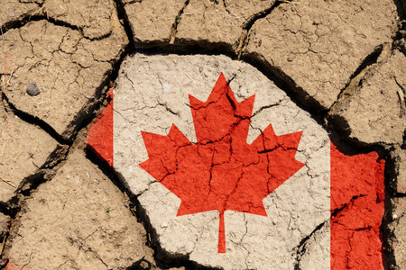 ecological concept. Drought. On dry, cracked ground, the image of the flag of Canada.の写真素材