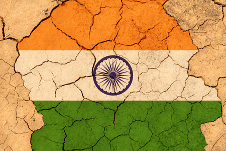 ecological concept. Drought. On dry cracked ground, the image of the flag of India.の写真素材