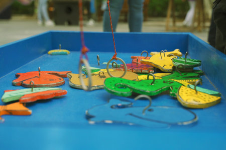 Children play a board wooden educational game - fishing. They catch fish from the field with a...