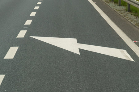 The white arrow on the pavement points to the left, the road narrows the carriageway.