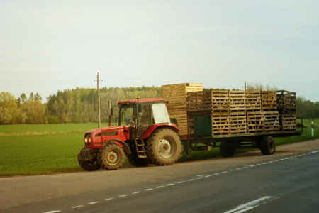 A tractor transports wooden containers in a trailer.の写真素材
