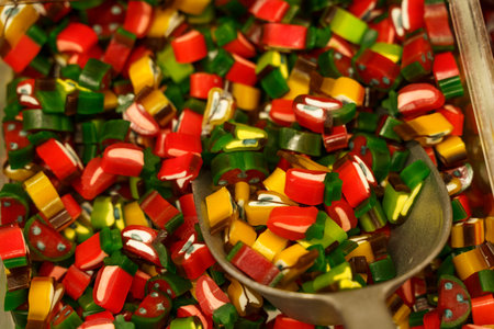 There are candies on the counter - colorful fruit gummies and a scoop. Candy store.の写真素材