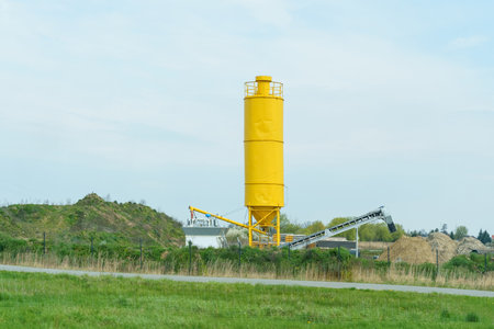 A yellow container for concrete mixers and an elevator for loading dump trucks.の写真素材