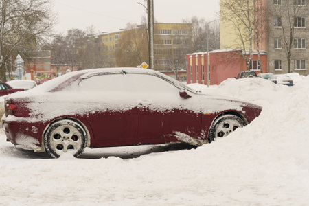 Heavy snowfall. A snow-covered car stands in a snowdrift.の写真素材
