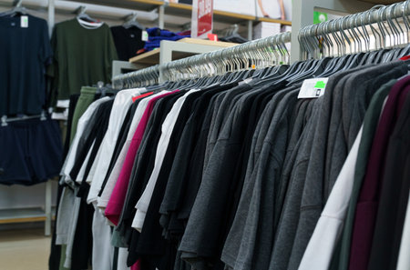 Men's T-shirts, selective focus. A row of men's T-shirts on hangers in a store. Close-up
