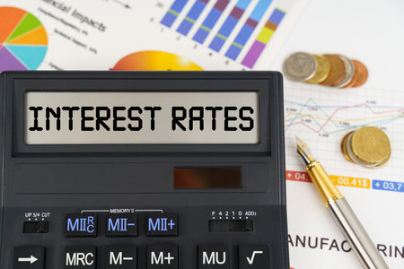 Business concept. On the table are financial reports, coins and a calculator with the description - Interest ratesの写真素材