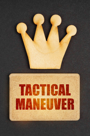 Business concept. On a black background there is a wooden crown of the leader and a sign with the inscription - Tactical Maneuverの写真素材