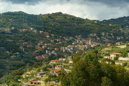 Cluster of houses settled on a mountain side, surrounded by greenery and overlooking the valley below.の写真素材
