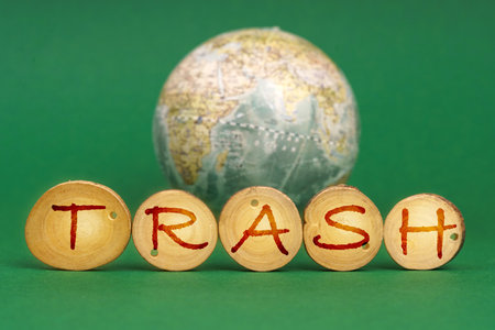 Ecological concept. On a green background there is an Earth globe and wooden roundels with the inscription - Trashの写真素材