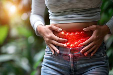 A woman standing while holding her stomach in evident discomfort and pain.の素材