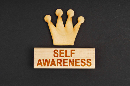 Leader concept. On a black surface there is a wooden crown and a block with the inscription - Self-awarenessの写真素材