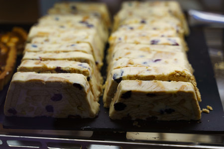 Rows of freshly cut cookie dough fudge with chocolate chips, ready for purchase at a local bakery.の写真素材