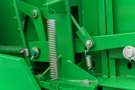 A detailed look at the mechanical parts of green industrial equipment, showing casing springs and bolted connections as part of the machinery assembly.の写真素材