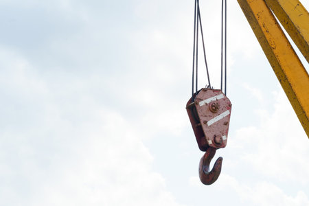 A crane hoisting a piece of equipment high into the air at a busy construction site.