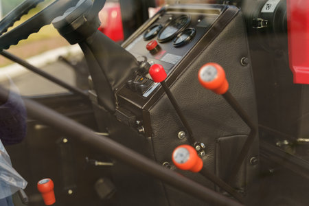 A close-up view highlighting the control levers inside the cabin of a tractor, showing the details...
