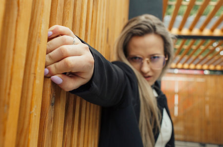 A female person grasping onto a wooden wall with her hands.の写真素材
