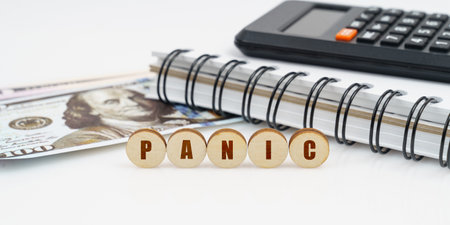 Business and finance concept. On a high surface lie a notepad, a calculator, dollars and wooden...